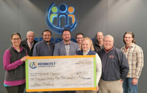 Image of Board Members, CEO and CFO with large check representing more than $175,000 going to members in December 2024.